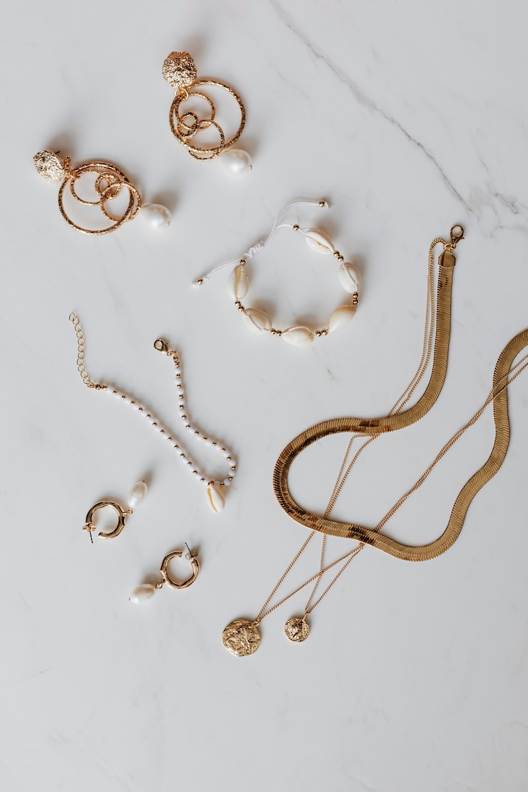 Photo vue aérienne de bijoux en or sur fond de marbre blanc