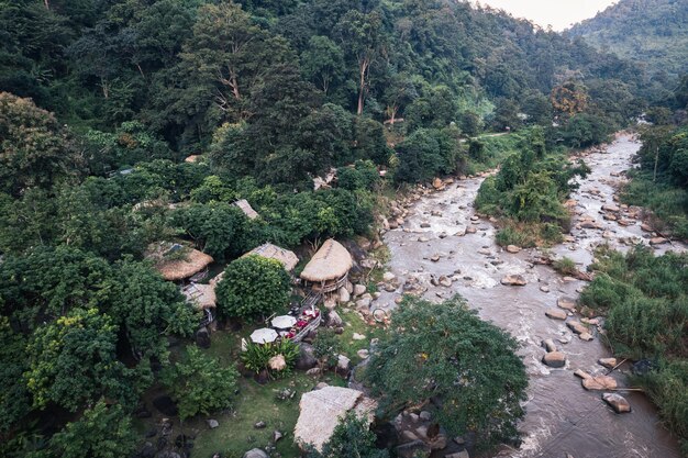 Vue aérienne d'un bungalow en bois dans la forêt tropicale avec des rapides naturels dans la vallée du parc national