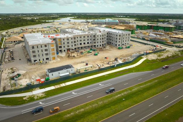 Vue aérienne de cadres inachevés d'immeubles d'appartements à proximité d'une artère de transport local en construction Développement de logements résidentiels dans les banlieues américaines Marché immobilier aux États-Unis