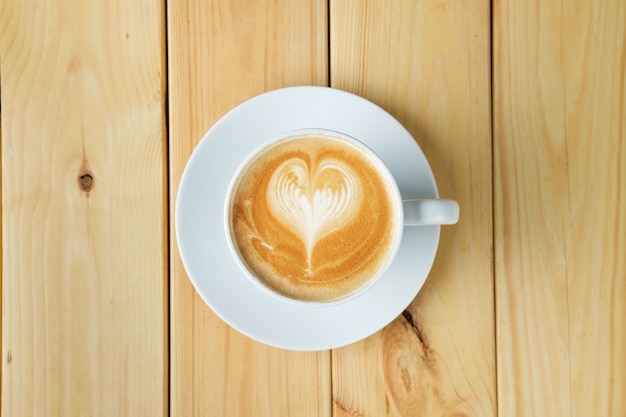 Vue aérienne de cappuccino dans une tasse en céramique sur une table en bois