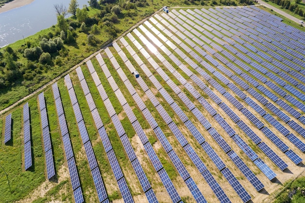 Vue aérienne de la centrale solaire sur champ vert. Ferme électrique avec panneaux pour la production d'énergie écologique propre.