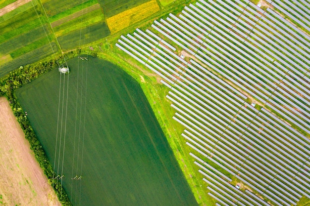 Vue aérienne de la centrale solaire sur champ vert. Panneaux électriques pour la production d'énergie propre.