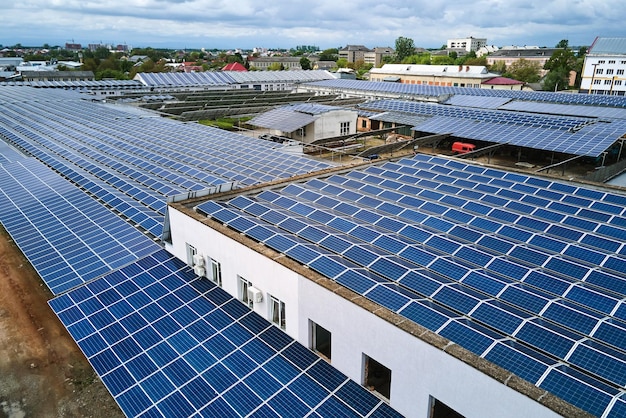 Vue aérienne de la centrale solaire avec des panneaux photovoltaïques bleus montés sur le toit d'un bâtiment industriel pour produire de l'électricité écologique verte. Production de concept d'énergie durable.