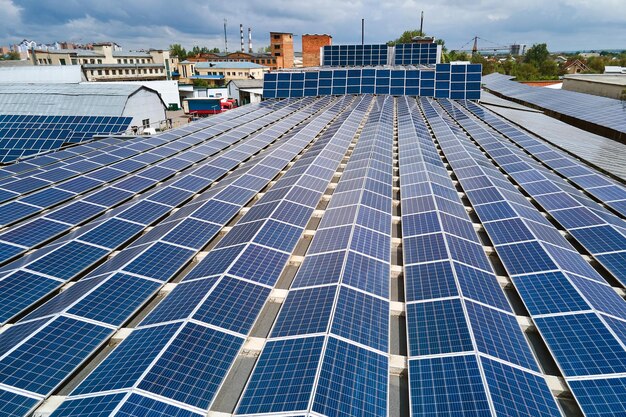 Vue aérienne de la centrale solaire avec des panneaux photovoltaïques bleus montés sur le toit d'un bâtiment industriel pour produire de l'électricité écologique verte Production d'un concept d'énergie durable