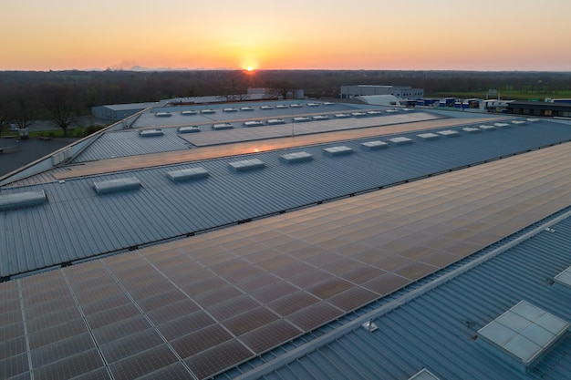 Vue aérienne d'une centrale solaire avec des panneaux photovoltaïques bleus montés sur le toit d'un bâtiment industriel pour produire de l'électricité écologique verte Production d'un concept d'énergie durable