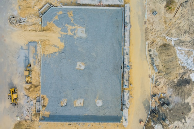 Vue aérienne sur le chantier de montage de murs de briques en béton sur la fosse de fondation