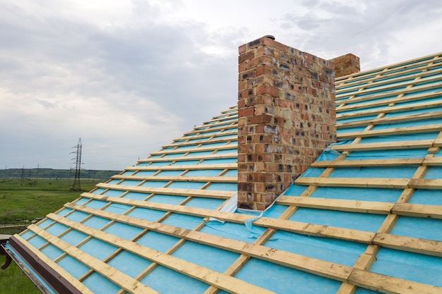 Vue aérienne d'une charpente en bois de maison en brique en construction.