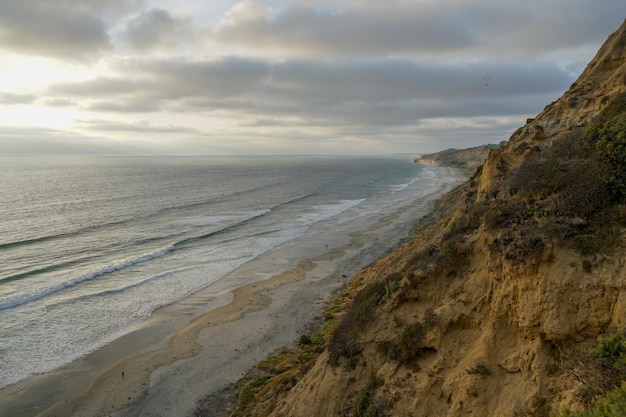 Vue aérienne de la côte pacifique avec des falaises de grès jaune et des vagues se précipitant sur la plage