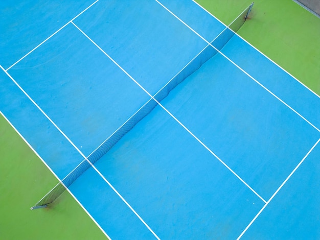 Photo vue aérienne d'un court de tennis bleu-vert serein dans un état vide