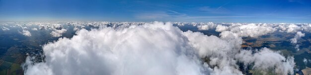Vue aérienne depuis la fenêtre d'un avion à haute altitude de la terre couverte de nuages cumulus blancs gonflés