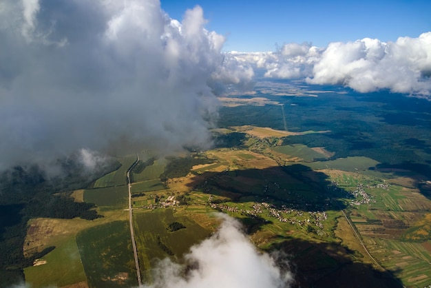 Vue aérienne depuis la fenêtre de l'avion à haute altitude de la terre recouverte de cumulus blancs gonflés.