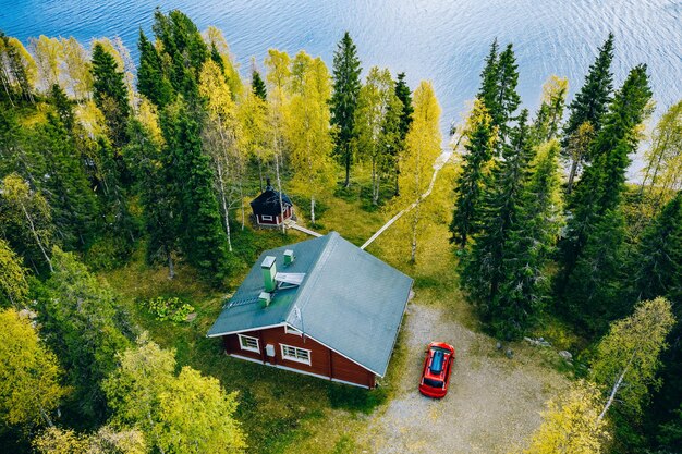 Vue aérienne de dessus d'une cabane en rondins ou d'un chalet avec sauna dans la forêt printanière au bord du lac dans la Finlande rurale