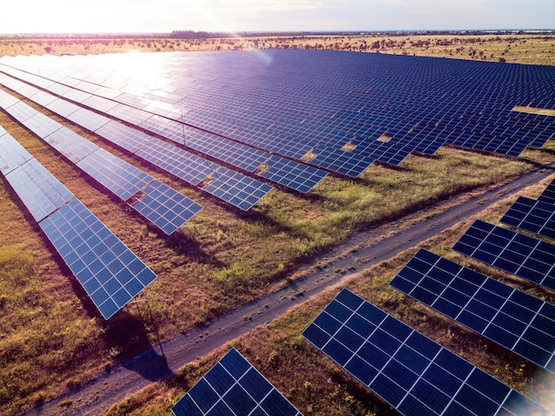 Vue aérienne de dessus d'une centrale de panneaux solaires panneaux solaires photovoltaïques au lever et au coucher du soleil à