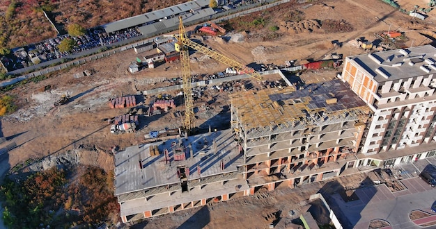 Vue aérienne de dessus du chantier de construction de nouveaux bâtiments à plusieurs étages grue à tour dans la tour d'habitation inachevée bu