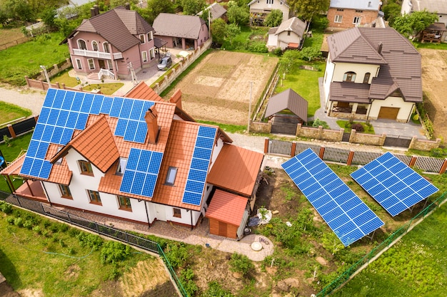 Vue aérienne de dessus du nouveau chalet de maison résidentielle moderne avec système de panneaux photovoltaïques photo bleu brillant sur le toit. Concept de production d'énergie verte écologique renouvelable.