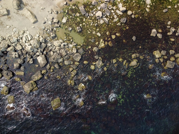 Vue aérienne de dessus de la plage rocheuse et des vagues de la mer