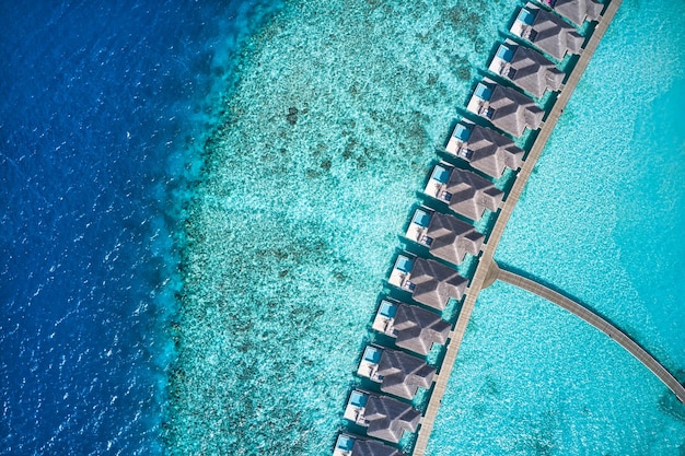 Vue aérienne de dessus de villas avec piscine, bungalows sur la plage tropicale paradisiaque des Maldives. Merveilleux bleu turquoise