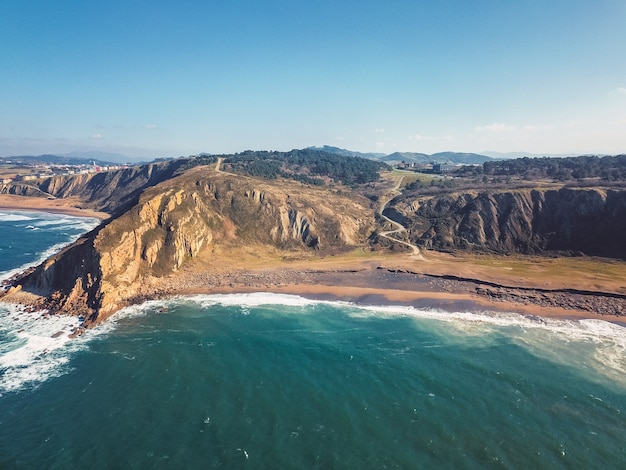 Vue aérienne de drone au-dessus des falaises sur une plage rocheuse et sablonneuse