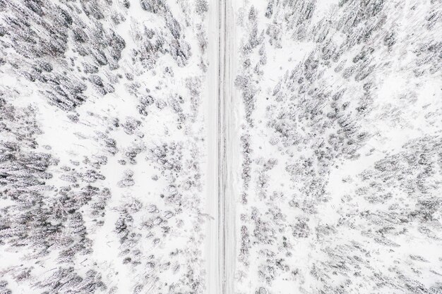 Vue aérienne de drone de route dans la forêt d'hiver.