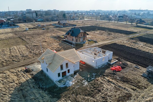 Vue aérienne du cadre inachevé d'une maison privée avec des murs en béton léger aéré et une charpente en bois en construction