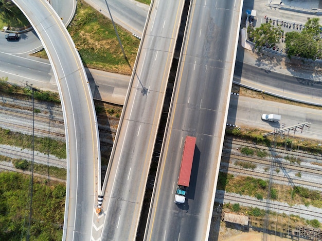 Vue aérienne du camion de fret sur la route avec conteneur rouge, concept de transport, importation, exportation logistique industrielle Transport terrestre sur l'autoroute asphaltée