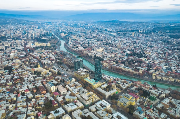 Vue aérienne du centre-ville de Tbilissi avec des églises et des bâtiments modernes et des eaux émeraude de la rivière Kura