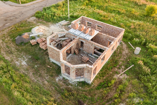 Vue Aérienne Du Chantier De Construction De La Future Maison, Du Sous-sol En Brique Et Des Piles De Briques Pour La Construction.