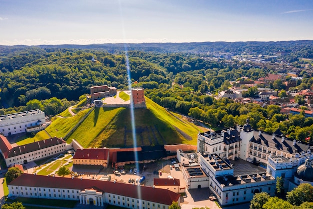 Vue aérienne du château de Gediminas dans la capitale Vilnius de Lituanie avec le drapeau lituanien sur la tour et les toits du centre-ville en arrière-plan.