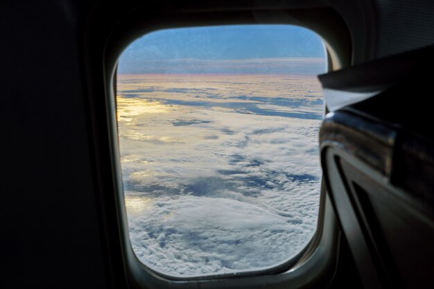 Vue aérienne du ciel bleu avec des nuages depuis la fenêtre du vol en jet