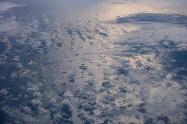 Vue aérienne du ciel et des nuages du soir au-dessus de l'océan depuis le hublot de l'avion Vol vers l'Islande au-dessus de l'Atlantique Nord