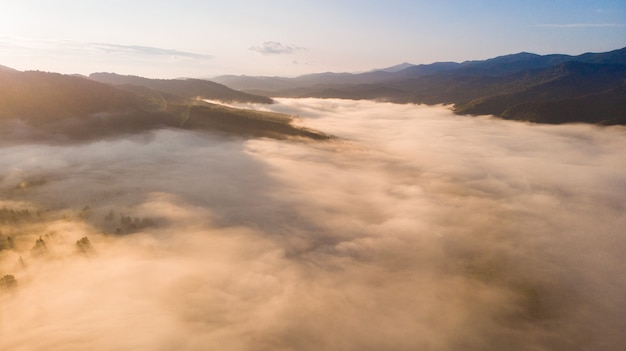 Vue aérienne du coucher de soleil d'automne dans les montagnes avec paysage de vallée de brouillard et de nuages