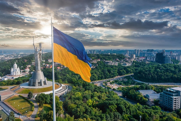 Vue aérienne du drapeau ukrainien flottant dans le vent contre la ville de Kiev