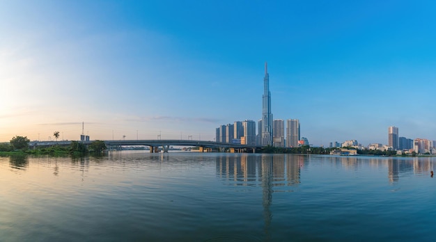 Vue aérienne du lever du soleil au point de repère 81, c'est un gratte-ciel super grand et un pont de Saigon avec des bâtiments de développement le long du paysage urbain de la rivière Saigon dans la belle matinée avec un petit brouillard autour de la ville