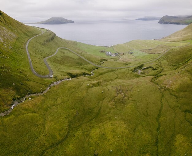 Photo vue aérienne du magnifique paysage des collines vertes de la côte des îles féroé de kalsoy