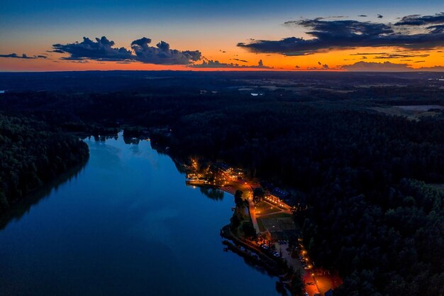 Vue aérienne du matin brumeux au bord du lac avec des maisons au crépuscule,