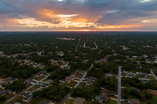 Vue aérienne du paysage de banlieue avec des maisons privées entre des palmiers verts en Floride quartier résidentiel calme le soir
