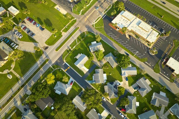 Vue aérienne du paysage de banlieue de la petite ville d'Amérique avec des maisons privées entre des palmiers verts dans un quartier résidentiel calme de Floride