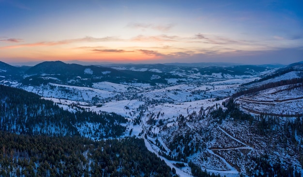 Vue aérienne du paysage mystique d'une forêt de montagne d'hiver un jour glacial nuageux. Le concept de la beauté dure des pays nordiques. Espace de copie