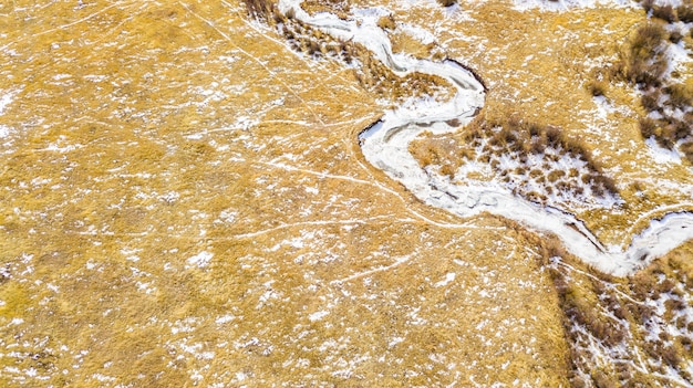 Vue aérienne du petit ruisseau de montagne en hiver.