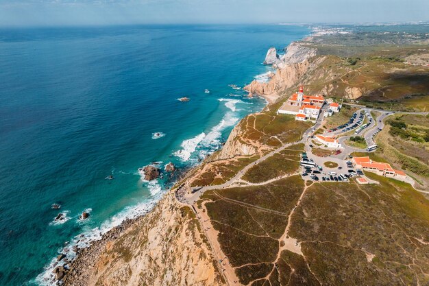 Vue aérienne du phare de Cabo da Roca avec des touristes non identifiés profitant de la vue étonnante. La plage d'Ursa est visible en arrière-plan.