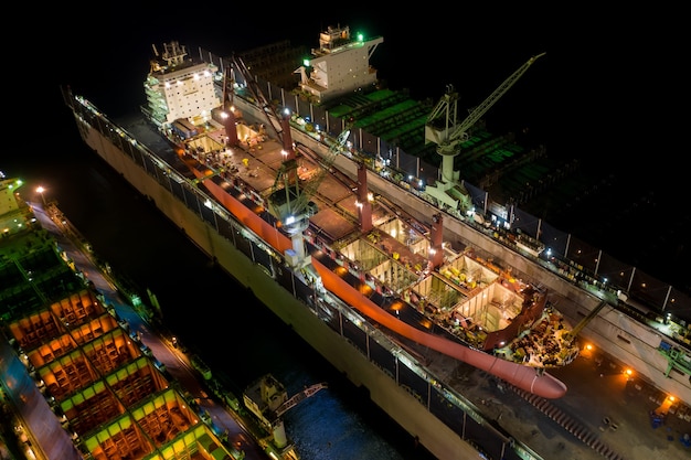 Vue aérienne du porte-conteneurs et de l'huile dans le chantier naval pour réparation de nuit. Peut utiliser pour le concept d'expédition ou de transport.