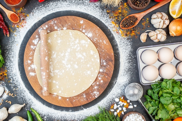 Vue aérienne du rouleau à pâtisserie sur la pâte circulaire