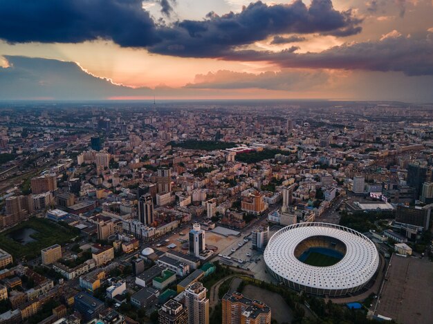 Vue aérienne du stade de football de la ville sur fond de coucher de soleil et de beaux nuages