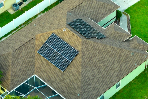 Vue aérienne du toit d'un bâtiment américain typique avec des panneaux solaires photovoltaïques bleus pour produire de l'énergie électrique écologique propre Investir dans l'électricité renouvelable pour le concept de revenu de retraite