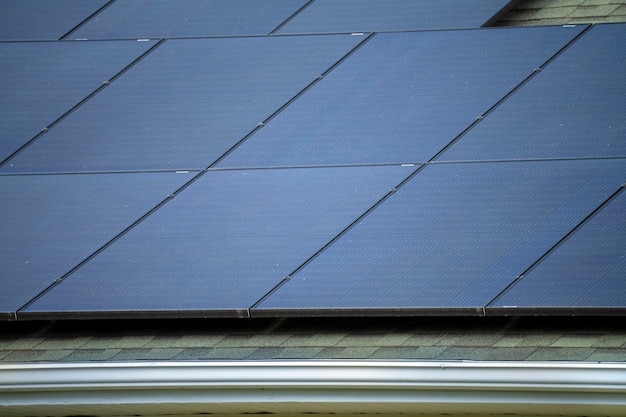 Vue aérienne du toit d'une maison américaine ordinaire avec des panneaux solaires photovoltaïques bleus pour produire de l'énergie électrique écologique propre Investir dans l'électricité renouvelable pour les revenus de retraite