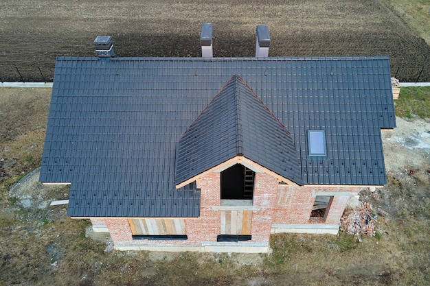 Vue aérienne du toit d'une maison recouvert de bardeaux en céramique Couvert de tuiles d'un bâtiment en construction