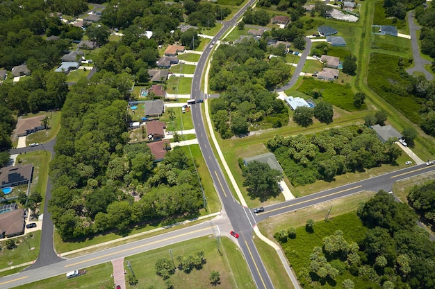 Vue aérienne du trafic routier avec conduite de voitures dans une petite ville Paysage de banlieue américaine avec des maisons privées entre des palmiers verts dans un quartier résidentiel calme de Floride