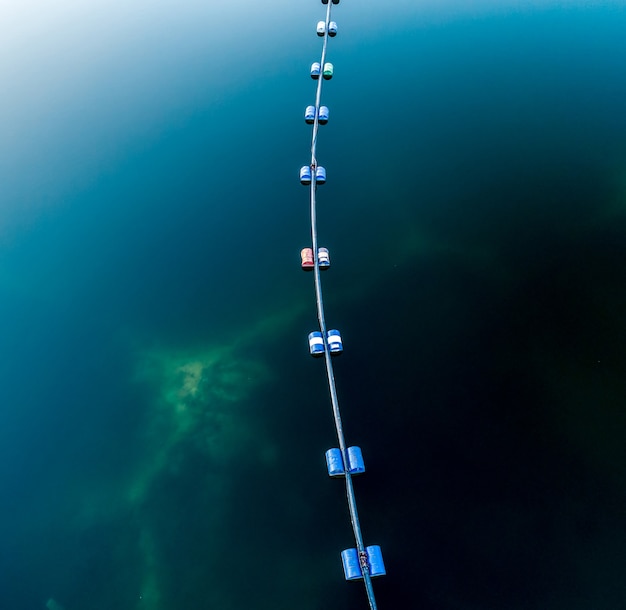 Photo vue aérienne du tube bleu avec des barils sur le lac