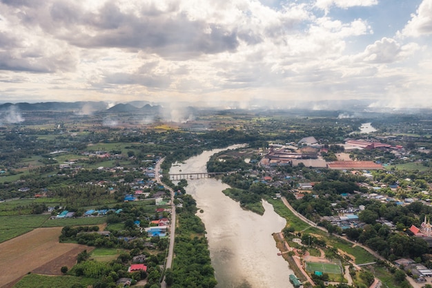 Vue aérienne du village sur la côte avec rivière et usine de transformation du sucre et fumée dans la plantation