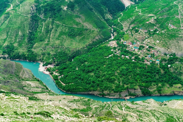 Vue aérienne du village de Old Zubutli dans la vallée de la rivière Sulak au Daghestan, petite colonie de montagne dans un profond canyon avec une jetée pour bateaux à moteur